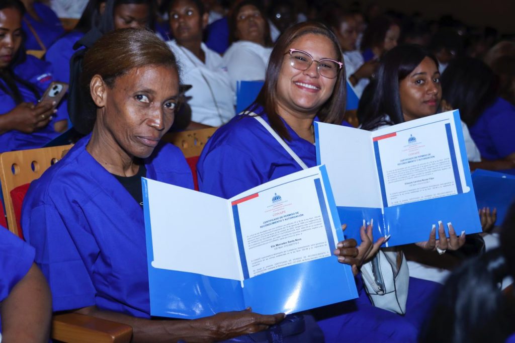 Mujeres muestran certificado que las habilita como personas cuidadoras