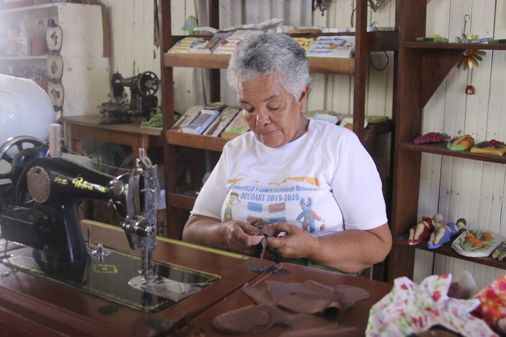 Participante realizando creaciones para la marca artesanal Manos Dominicanas.